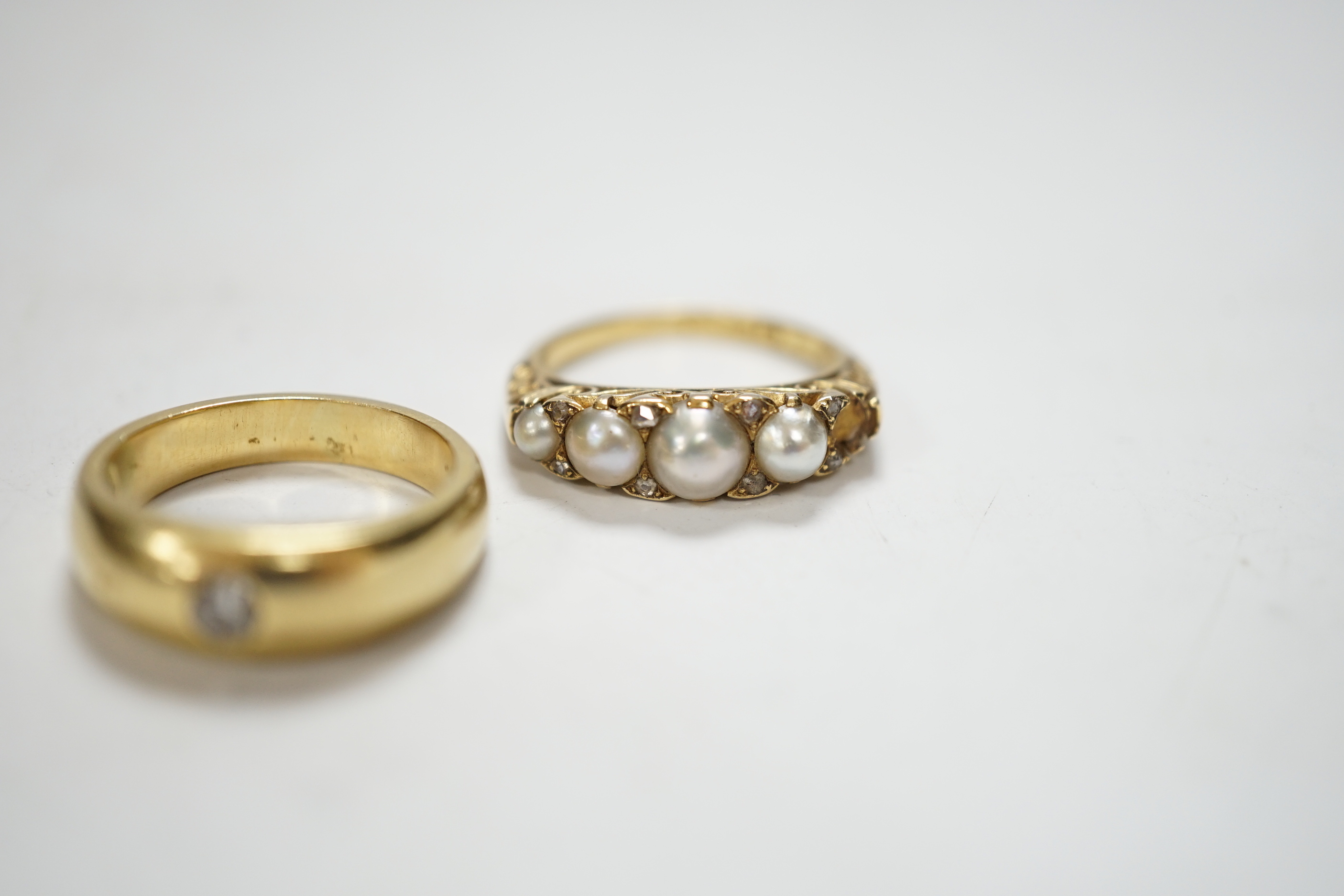 An early 20th century yellow metal and graduated split pearl set half hoop ring, with diamond chip spacers (pearl missing), size K/L, gross weight 4.5 grams, together with a yellow metal and gypsy set solitaire diamond r